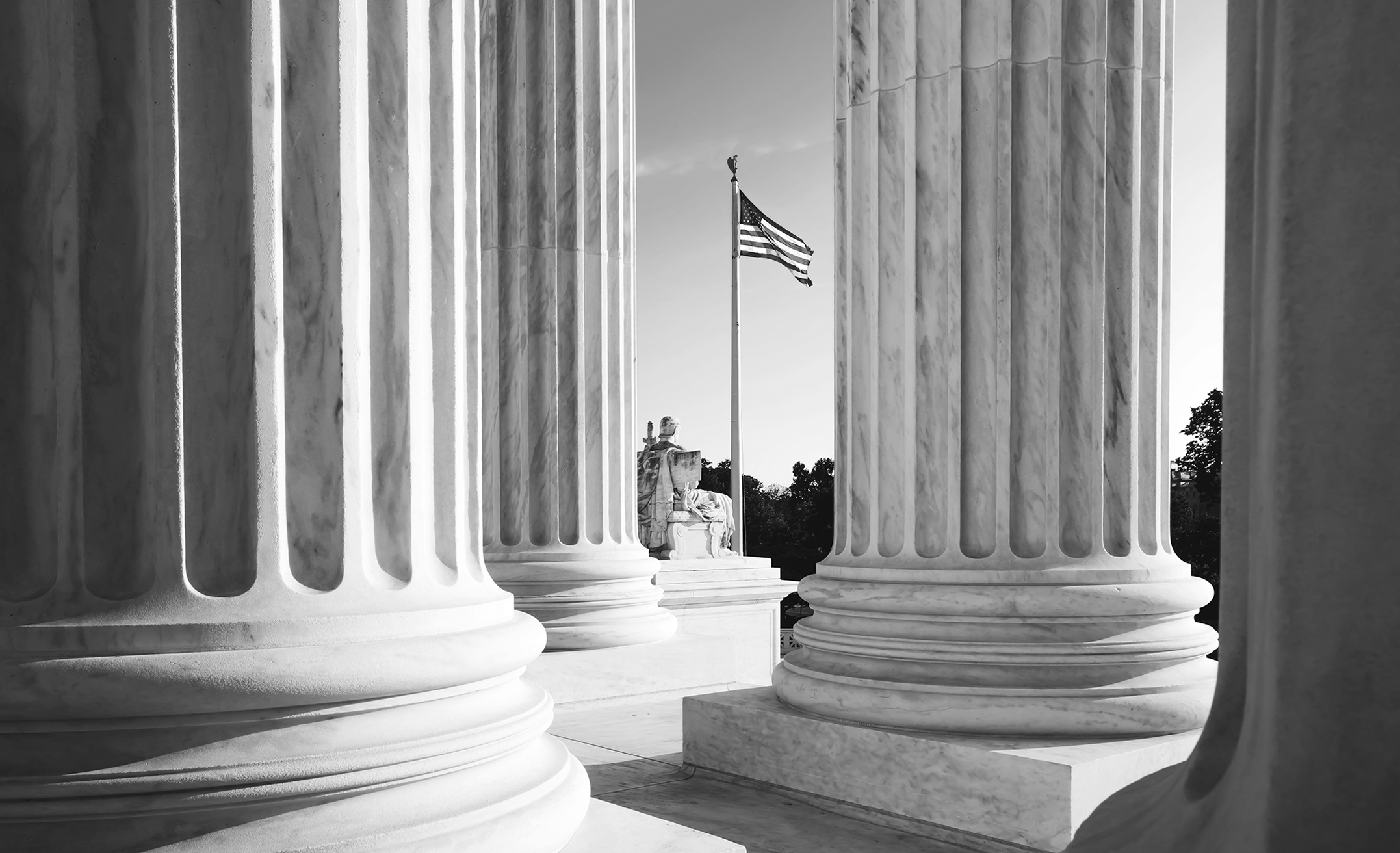 U.S. flag viewed through pillars of government building 